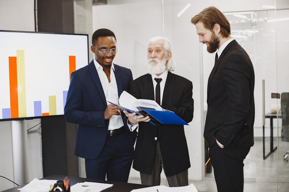 A diverse team of businessmen discussing reports in a modern office setting.